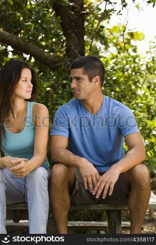 Young woman and a mid adult man looking at each other