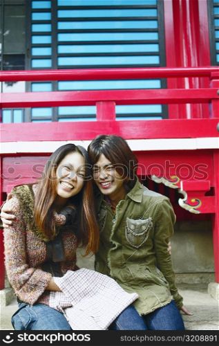 Young woman and a mid adult man sitting together and smiling
