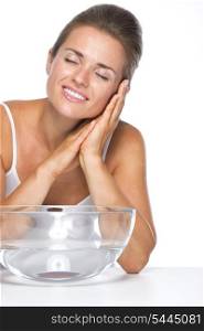 Young woman and glass bowl with water enjoying freshness