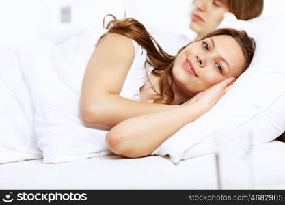 Young woman and her husband in a bed