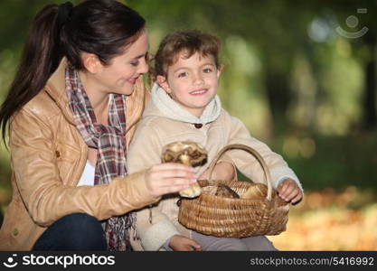 Young woman and little girl with basket of mushrooms