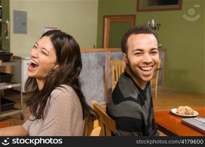 Young Woman and Man Laughing Back-to-back