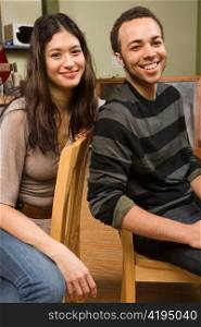 Young Woman and Man on Diner Chairs