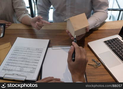 Young woman and man signing contract making a deal with real estate agent