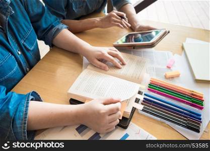 Young woman and man studying for a test/ an exam. Tutor books with friends