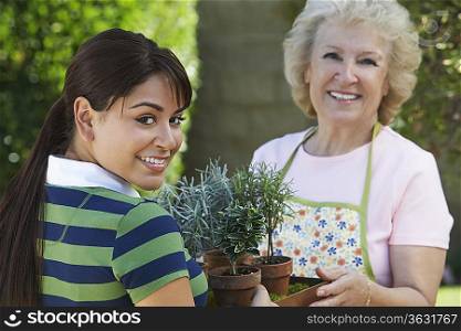 Young woman and mother gardening, portrait