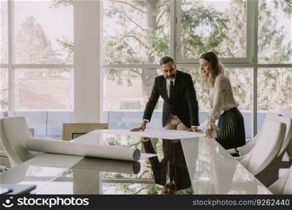 Young woman and senior businessman discuss about new project in modern office
