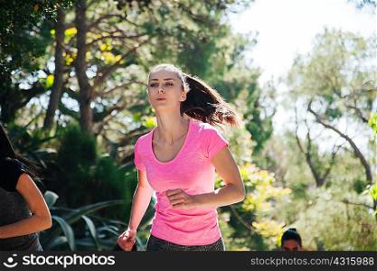 Young woman and team running through park, Split, Dalmatia, Croatia