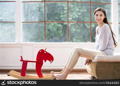 Young woman and wooden horse toy