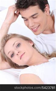 Young woman and young man laid on a couch