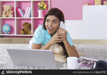 Young woman answering smart phone at home