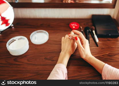 Young woman applies hand cream to skin. Morning skincare procedure. Woman applies hand cream to skin at the mirror
