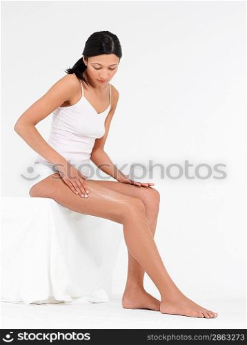 Young Woman Applying Body Lotion