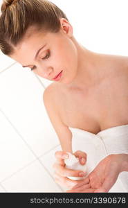 Young woman applying lotion in the bathroom