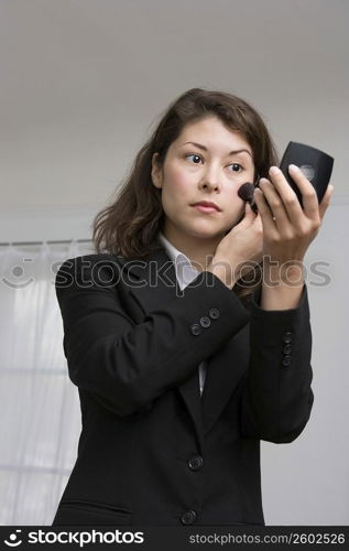 Young woman applying makeup