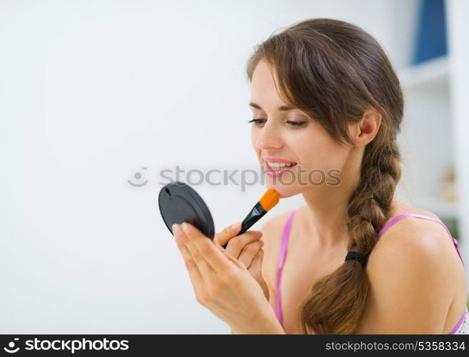 Young woman applying makeup