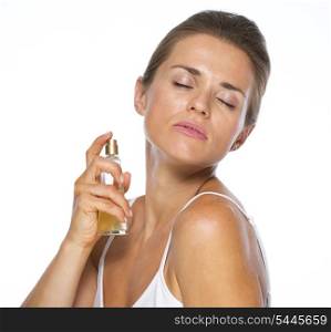 Young woman applying perfume