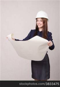 Young woman architect in hardhat standing with blueprints in hand