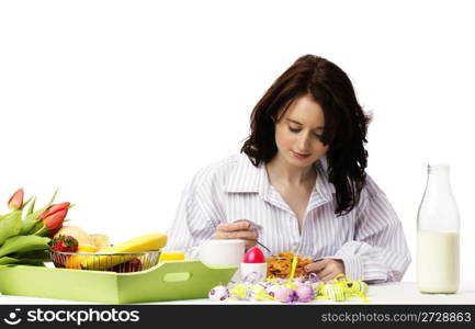 young woman at breakfast eating corn flakes. young woman at easter breakfast eating corn flakes