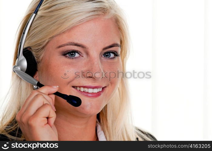 young woman at computer with headset and hotline.