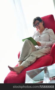 Young woman at home relaxing in her lliving room reading a digital tablet PC surf internet and work