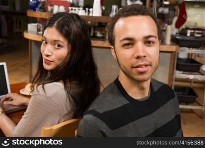 Young Woman at Laptop with Man at her Back