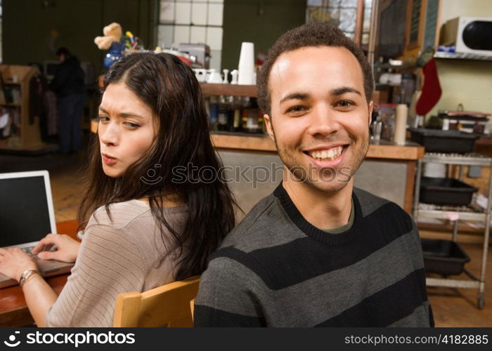 Young Woman at Laptop with Man at her Back