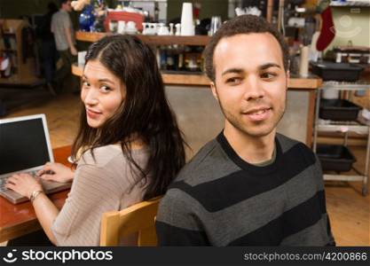Young Woman at Laptop with Man at her Back