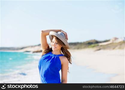 Young woman at the beach. Portrait of young pretty woman wearing hat at the beach