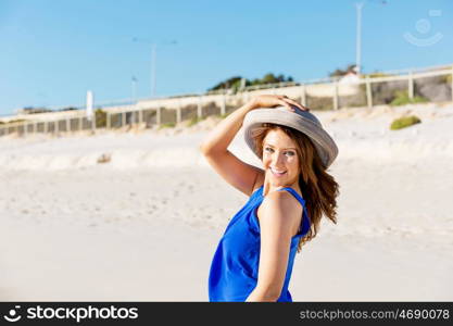 Young woman at the beach. Portrait of young pretty woman wearing hat at the beach