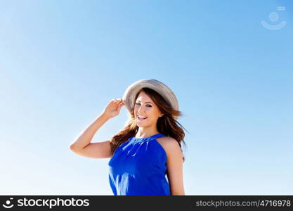 Young woman at the beach. Portrait of young pretty woman wearing hat at the beach