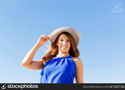 Young woman at the beach. Portrait of young pretty woman wearing hat at the beach