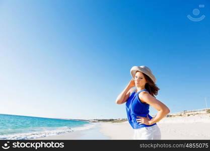 Young woman at the beach. Portrait of young pretty woman wearing hat at the beach