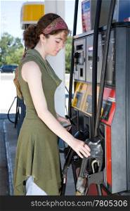 Young woman at the gas station, getting ready to fill up her car.
