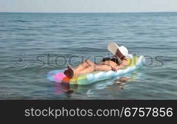 Young woman at the sea on an inflatable float