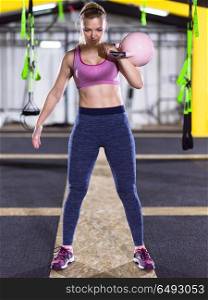young woman athlete exercise with fitness kettlebell at crossfitness gym. woman exercise with fitness kettlebell