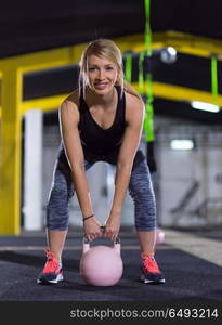 young woman athlete exercise with fitness kettlebell at crossfitness gym. woman exercise with fitness kettlebell