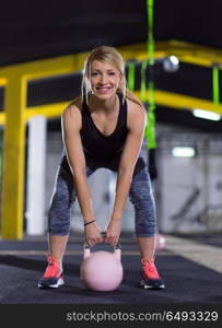 young woman athlete exercise with fitness kettlebell at crossfitness gym. woman exercise with fitness kettlebell