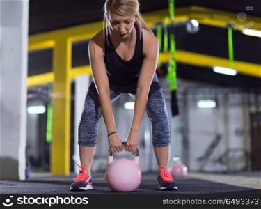 young woman athlete exercise with fitness kettlebell at crossfitness gym. woman exercise with fitness kettlebell