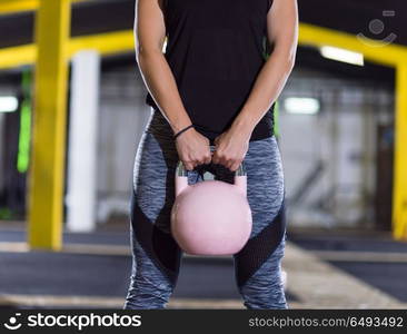 young woman athlete exercise with fitness kettlebell at crossfitness gym. woman exercise with fitness kettlebell