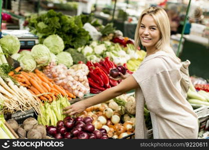 Young woman baying vegetable on the market