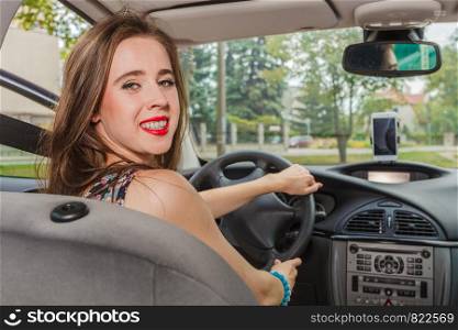 Young woman behind steering wheel. Female passing driver license exam, driving a car.. Woman driving a car