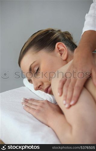 Young woman being massaged in beauty parlor