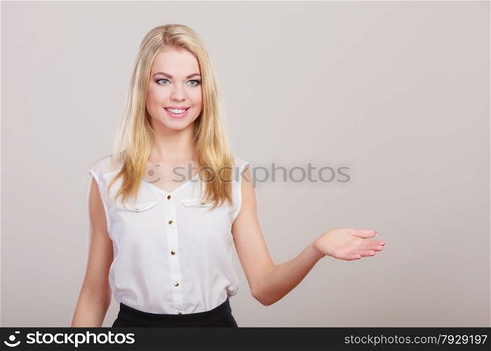 young woman blonde smile girl making welcome invitating hand sign gesture. Studio shot on gray