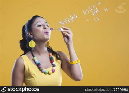 Young woman blowing bubbles