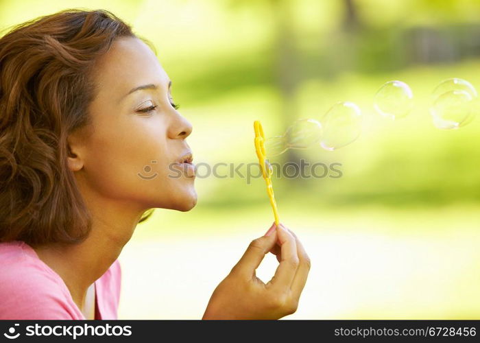 Young woman blowing bubbles