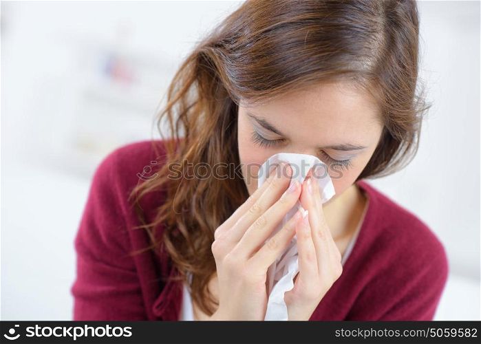 young woman blowing nose