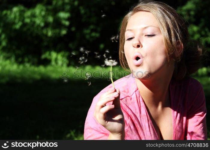 young woman blowing on the dandelion &#xA;