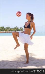 Young Woman Bouncing Ball at the Beach