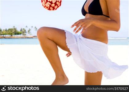 Young Woman Bouncing Ball at the Beach